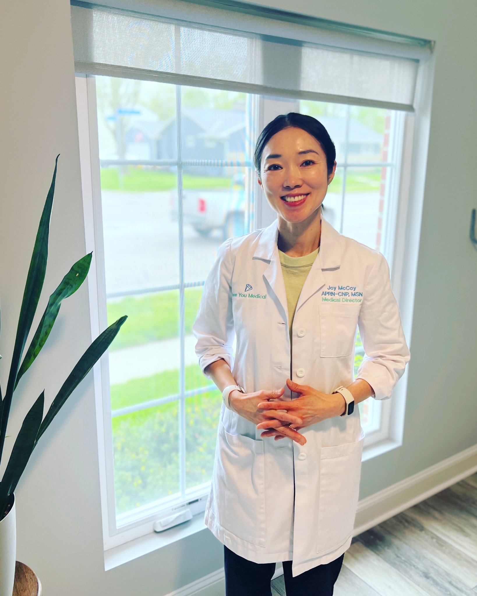 Joy Mccoy, provider at New You Medical, standing in a bright clinic room with large windows overlooking the Powell, OH area